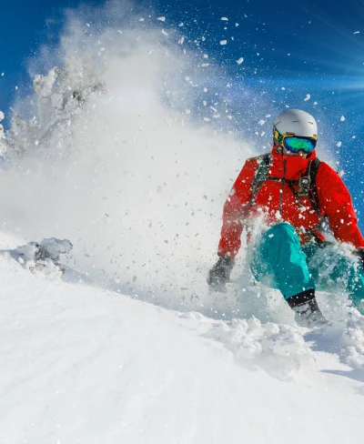 Skier skis down a snowy piste