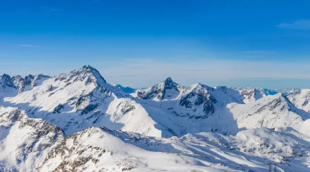 White mountains in the Alps under a blue sky