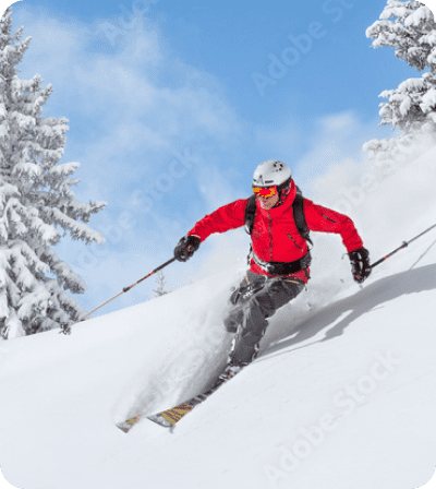 A skier wearing red skiing down the mountain